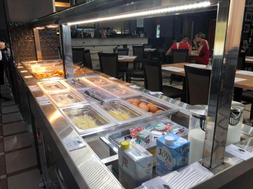 a buffet line in a restaurant with food on it at Athina Airport Hotel in Thérmi