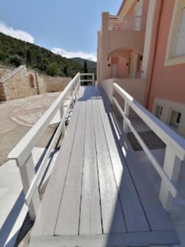 a wooden bench sitting on the side of a building at Hestia in Áyioi Apóstoloi
