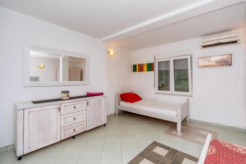 een witte kamer met een bank en een raam bij Apartmani LIRA in Sutomore