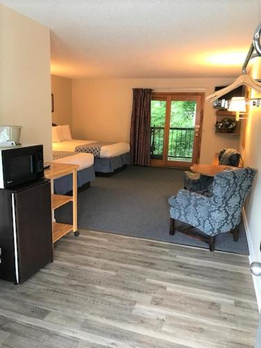 a hotel room with two beds and a desk and a chair at Four Seasons Inn in Maggie Valley