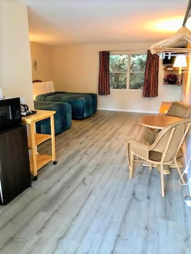 a living room with a table and a bed at Four Seasons Inn in Maggie Valley