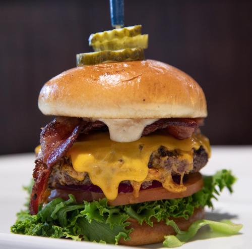 un cheeseburger avec du fromage et des pickles sur une assiette dans l'établissement Wyndham Moline on John Deere Commons, à Moline