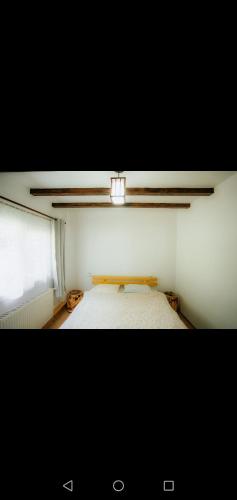 an empty room with a bed and a light at Casa Pietrosu Rodnei in Borşa