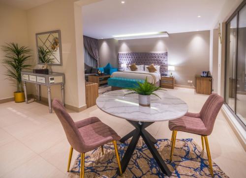 a living room with a bed and a table and chairs at The Address Palace Apartments in Dammam