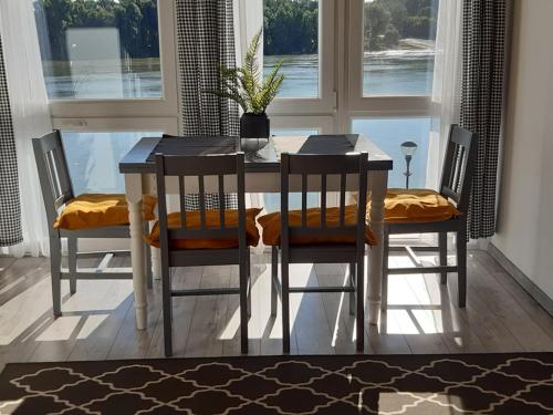 a dining room table with four chairs and a window at Duna Kuckó in Mohács