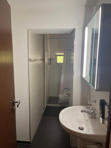 Haus Alpenhof في فيسين: حمام أبيض مع حوض ومرحاض