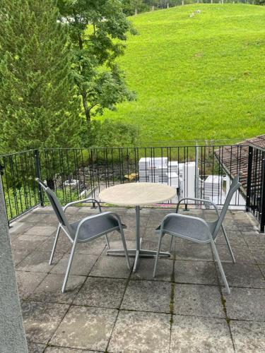una mesa y dos sillas sentadas junto a una mesa en Haus Alpenhof, en Wassen