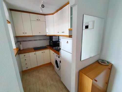 a small kitchen with white cabinets and a white refrigerator at Park Beach La Mata in La Mata