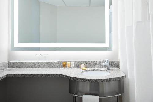 a bathroom with a sink and a large mirror at Club Quarters Hotel White House, Washington DC in Washington, D.C.