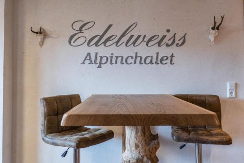 a table with two chairs and a sign that reads excellence antiparticle at Chalet EDELWEISS in Ladis