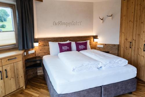 a bedroom with a large white bed with red pillows at Chalet EDELWEISS in Ladis