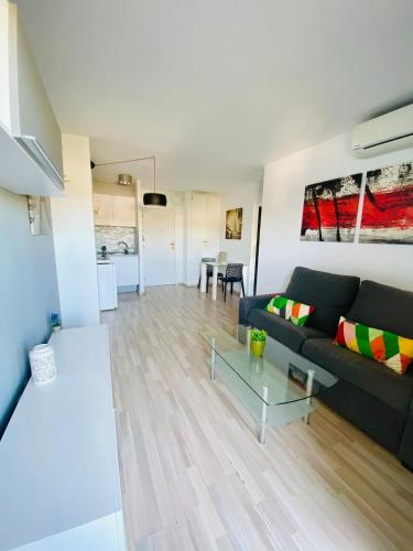 ein Wohnzimmer mit einem Sofa und einem Tisch in der Unterkunft ARQUUS APARTMENT SALOU BEACH in Salou