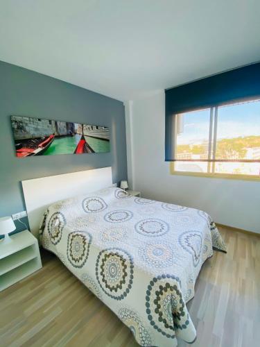 ein Schlafzimmer mit einem Bett und einem TV an der Wand in der Unterkunft ARQUUS APARTMENT SALOU BEACH in Salou