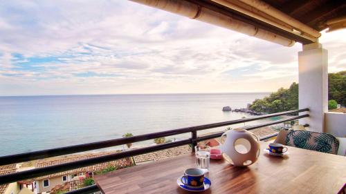 a table with a view of the ocean from a balcony at Glyfada Home 113 by New Era in Menigos Resort Apartments in Glyfada