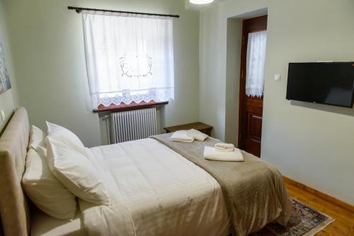 a bedroom with a bed and a flat screen tv at ΔΗΜΗΤΣΑΝΑΣ ΤΟΠΟΣ Νύμφη Νέδα in Dhimitsana