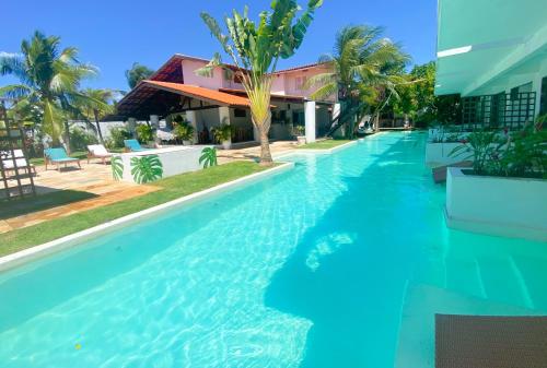 een zwembad met blauw water voor een gebouw bij Kite Soul Pousada in Cumbuco