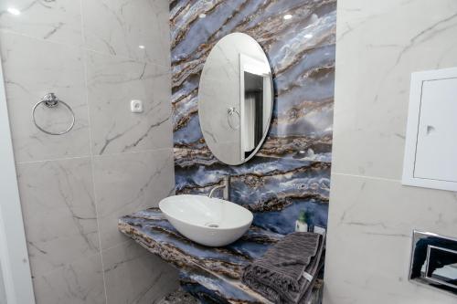 a bathroom with a sink and a mirror at LUX 6 МКР дизайнерская комфортная студия с панорамными дверьми и большой лоджией in Uralsk