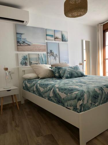een slaapkamer met een bed met een groen dekbed bij Cerezo's House - Terrace & Jacuzzi in Frigiliana