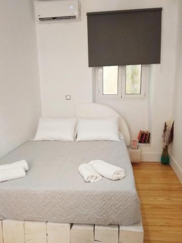 a bedroom with two beds with white sheets and a window at Corfu Mariú Suite by Liston in Corfu