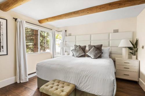 a white bedroom with a large bed and a window at 700 Monarch 201 in Aspen