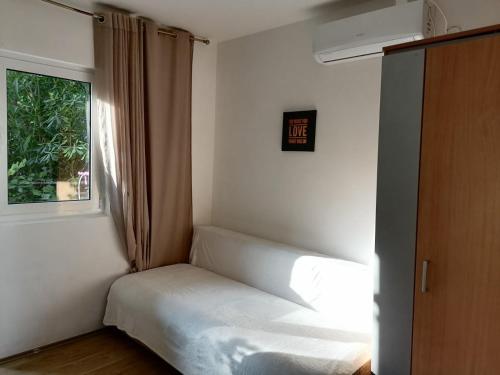 ein kleines Bett in einem Zimmer mit Fenster in der Unterkunft Candy apartment central location Bečići in Becici