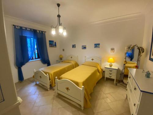 オストゥーニにあるVILLA GAIAの青いカーテンが備わる客室のベッド2台