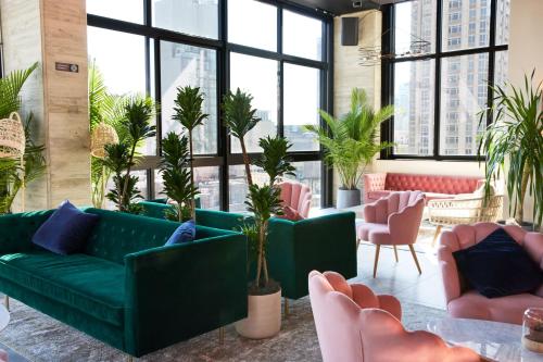 a living room with a green couch and pink chairs at Hotel Hendricks in New York