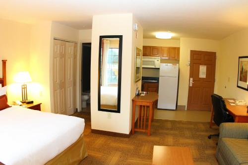a hotel room with a bed and a kitchen at Staybridge Suites Houston - Willowbrook by IHG in Houston