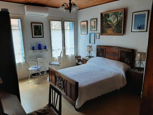 a bedroom with a bed and a table and chairs at Les Chambres Chouettes in Villefranche-de-Conflent
