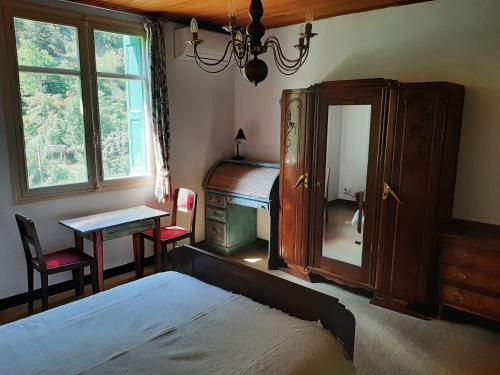 a bedroom with a bed and a desk and a mirror at Les Chambres Chouettes in Villefranche-de-Conflent