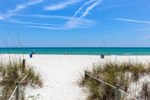 a white sandy beach with people in the ocean at Casa Sunshine Townhouse in Sunnyside