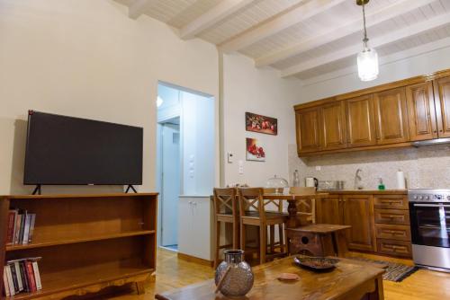 a kitchen with a flat screen tv and a table at ΔΗΜΗΤΣΑΝΑΣ ΤΟΠΟΣ Νύμφη Αγνώ in Dimitsana