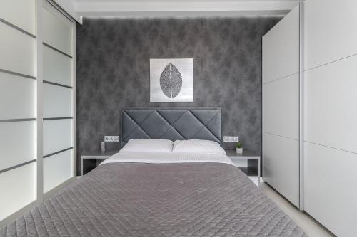 a bedroom with a large bed with a headboard at Magic Apart 10 in Lviv