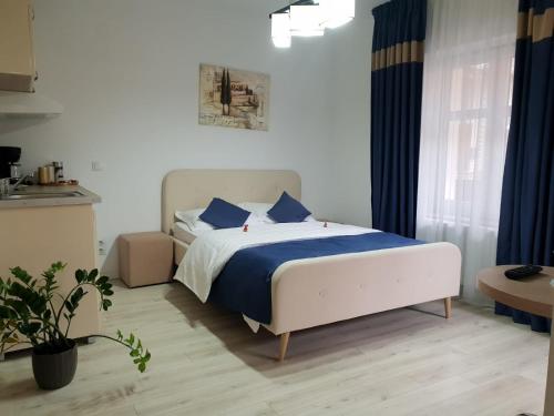 a bedroom with a bed with blue and white sheets at Studio Piata Mare apartments in Sibiu