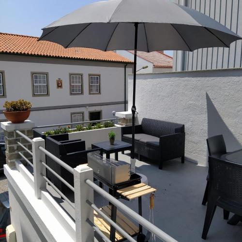 a patio with an umbrella and a table and chairs at Portela House - T3 Residential home 50 meters from the beach in Vila Praia de Âncora