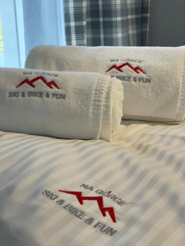 łóżko z 2 poduszkami i 2 ręcznikami w obiekcie Apartament Na Górce, sauna & jacuzzi w Szczyrku