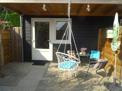 a porch with a swinging chair and a table at B&B Het Onderduukertje in Wemeldinge