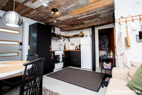 a small kitchen with a white refrigerator and a table at Tyynynpaikka in Tampere