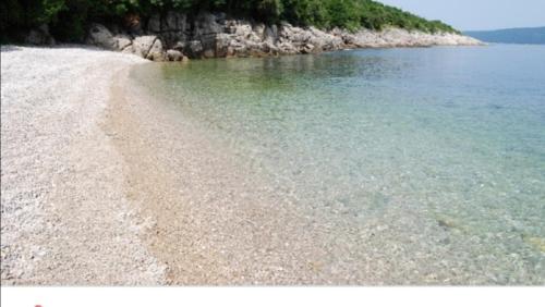 a beach with rocks and the water at Matea in Plomin