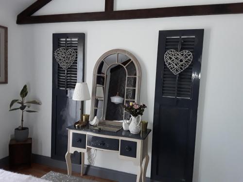 a room with a table with a mirror and a door at Ballybur Lodge Mews 2 in Kilkenny