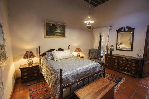 a bedroom with a bed and two dressers and a mirror at Casa Quintana in San Miguel de Allende