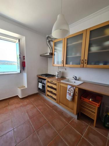 a kitchen with wooden cabinets and a sink and a window at Herdade Monte da Tapada in Alqueva