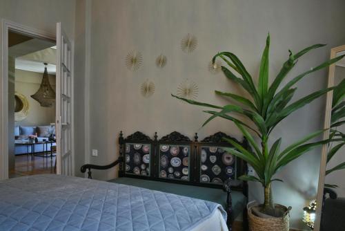 a bedroom with a bed and a potted plant at Pepromeno LUXURY APARTMENT IN THE CITY CENTER in Kalamata