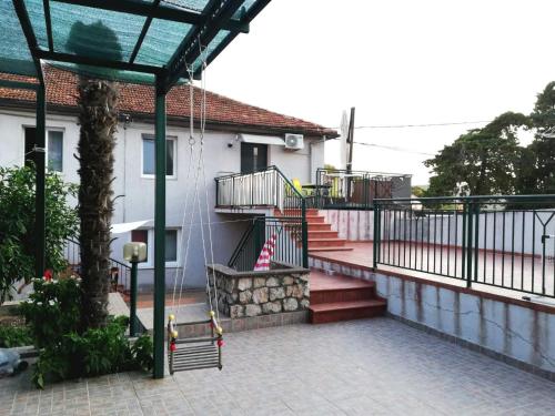 a house with a porch with stairs and a fence at Apartman Kristina in Tisno