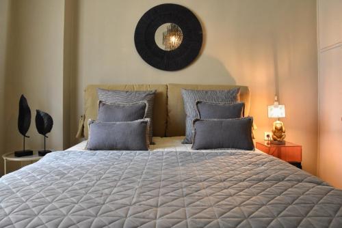 a bedroom with a large bed with blue pillows at Pepromeno LUXURY APARTMENT IN THE CITY CENTER in Kalamata