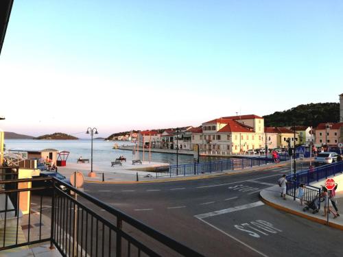 a street in a town with a beach and the ocean at Apartman Kristina in Tisno