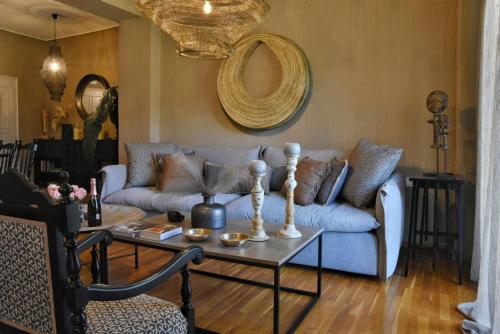 a living room with a blue couch and a table at Pepromeno LUXURY APARTMENT IN THE CITY CENTER in Kalamata