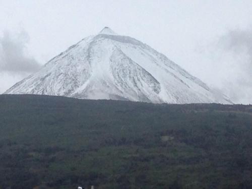 a snow covered mountain on top of a hill at Adega Do Mirante in São Roque do Pico