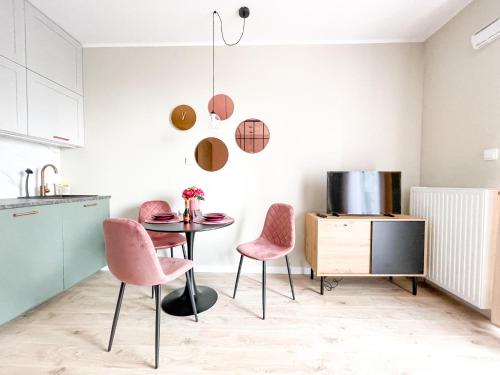 uma cozinha com uma mesa e duas cadeiras cor-de-rosa em SuperApart Omulewska em Varsóvia