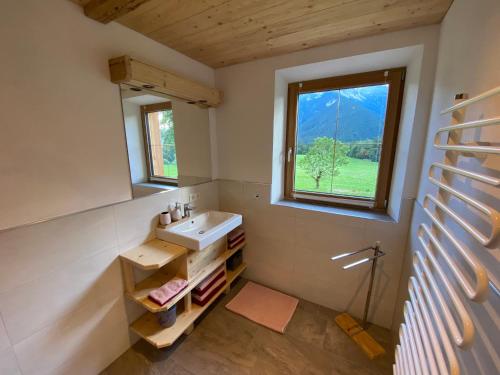 La salle de bains est pourvue d'un lavabo et d'une fenêtre. dans l'établissement Haidacherhof, à Eben am Achensee